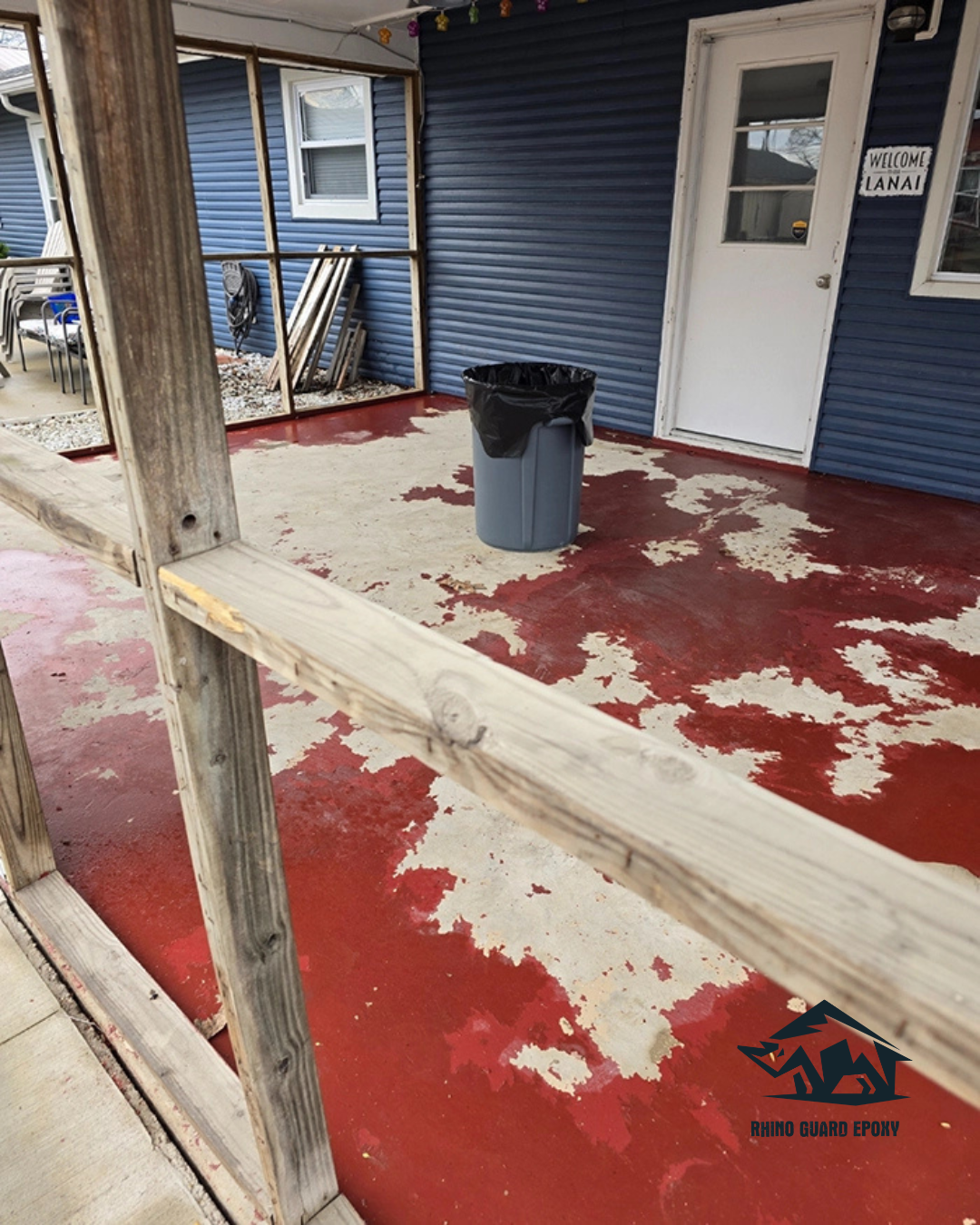 Porch area with blue siding, peeling red epoxy floor revealing beige underneath, and a gray trash can with a black liner near a white door.